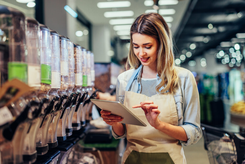 Woman Working At A Grocery Store And Using Tablet for LMS learning.